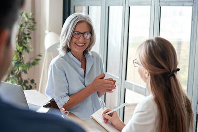 woman in glasses being checked in at a dental office