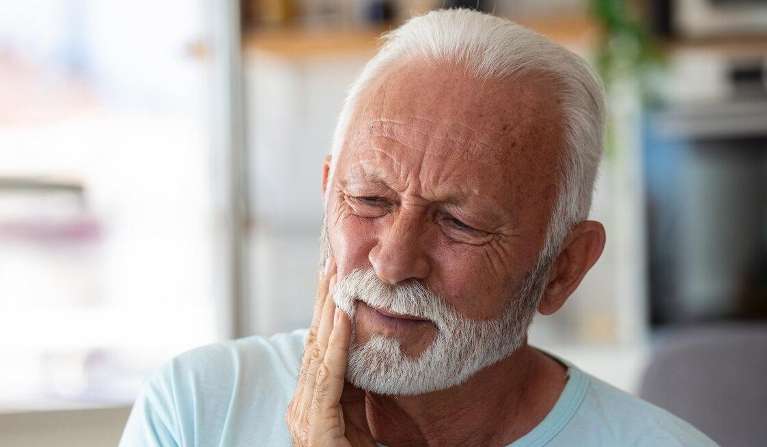 man holding jaw from tooth pain